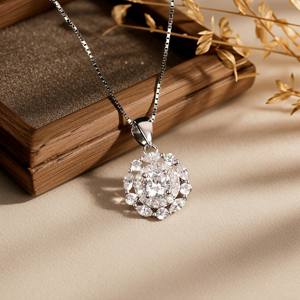 silver necklace with a diamond pendant on a textured surface